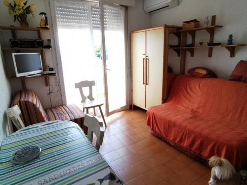 1 dormitorio con 1 cama y 1 habitación con TV en Appartement Argelès-sur-Mer, 1 pièce, 3 personnes - FR-1-732-2, en Argelès-sur-Mer