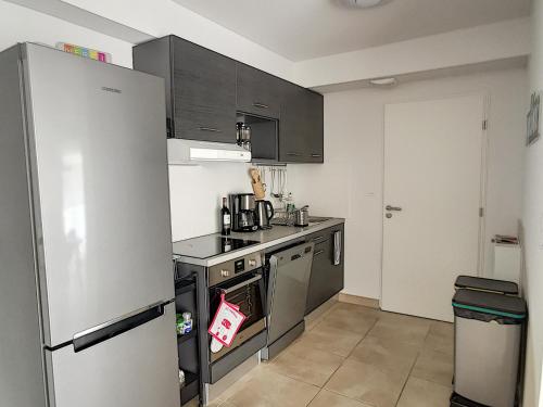 une cuisine avec une cuisinière et un réfrigérateur dans l'établissement T3 neuf climatisé avec terrasse, piscine et parking à Argelès-sur-Mer - FR-1-732-27, à Argelès-sur-Mer