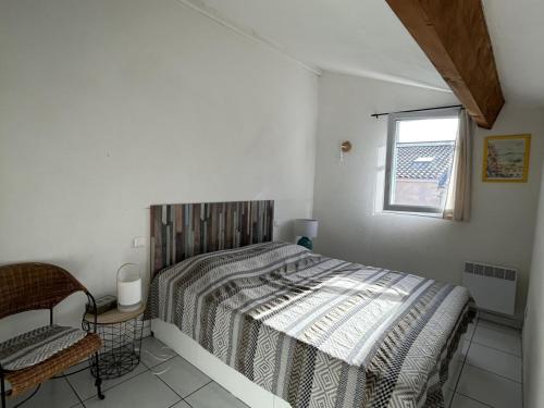 une chambre avec un lit, une chaise et une fenêtre dans l'établissement Charmant pavillon avec piscine et animaux acceptés - Sorède - FR-1-732-32, à Sorède