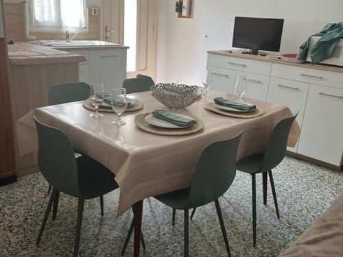 - une table à manger avec des chaises et une table avec des verres à vin dans l'établissement Maison 2 chambres à Saint-André, proche plages et Espagne, terrasse spacieuse, ménage inclus - FR-1-732-36, à Saint-André