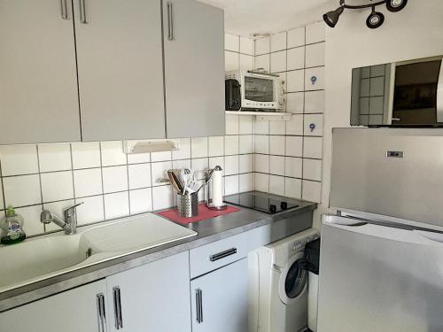 La cuisine blanche est équipée d'un évier et d'un réfrigérateur. dans l'établissement Pavillon 2 étoiles climatisé, 4 pers, parking, Argelès-sur-Mer - FR-1-732-28, à Argelès-sur-Mer