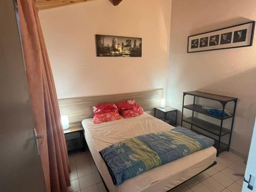 - une chambre avec un lit doté d'oreillers rouges dans l'établissement Pavillon 2 étoiles climatisé, 4 pers, parking, Argelès-sur-Mer - FR-1-732-28, à Argelès-sur-Mer