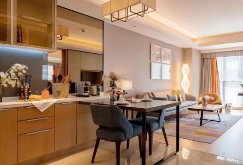 kuchnia i salon ze stołem i krzesłami w obiekcie HongQiao Primus Residence Apartment - National Exhibition Center w Szanghaju
