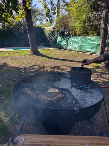 una persona cocinando comida en una olla en una parrilla en Casa quinta Los Mellis en La Reja