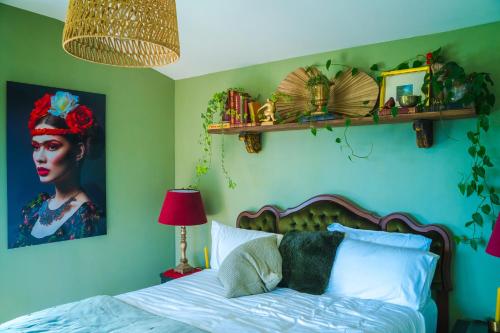 a bedroom with a bed with a painting of a woman at Fridas Accommodation in Raglan