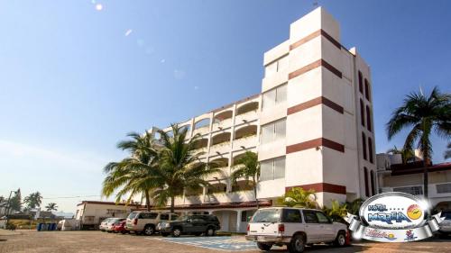 a building with cars parked in a parking lot at Hotel Marbella in Manzanillo