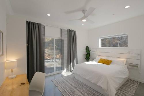 Habitación blanca con cama y ventana en Eagle Rock Nest ～Quiet & Gorgeous Mountain Views en Three Rivers