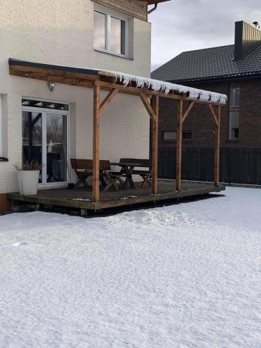 a wooden deck with a picnic table with snow on it at Pilaites svetingi namai in Vilnius