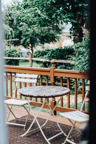 a wooden table and two chairs next to a fence at East Stevens Home in Culpeper
