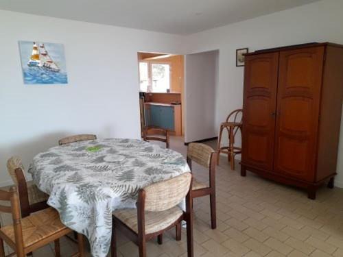 une salle à manger avec une table, des chaises et une armoire dans l'établissement Villa T4 plain-pied proche plage, terrasse, parking, animaux acceptés - Saint-Gilles-Croix-de-Vie - FR-1-324-559, à Saint-Gilles-Croix-de-Vie