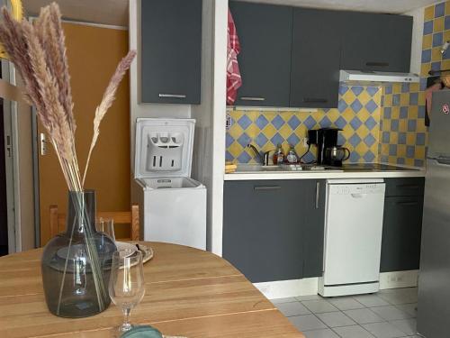 eine Küche mit einem Tisch und einer Vase darüber in der Unterkunft Maison Argelès-sur-Mer, 3 pièces, 4 personnes - FR-1-732-47 in Argelès-sur-Mer