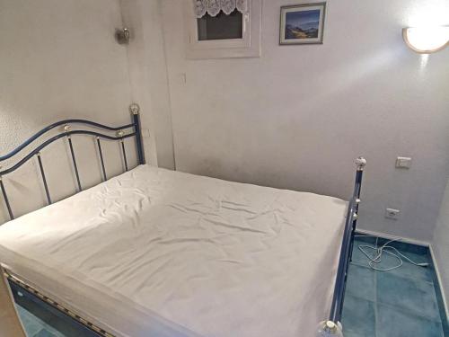 - un lit avec un drap blanc dans une chambre dans l'établissement Pavillon confortable à 10 min de la mer avec terrasse, parking et local à vélo - FR-1-732-48, à Argelès-sur-Mer