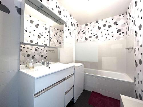 une salle de bain blanche avec un lavabo et une baignoire dans l'établissement Spacieux appartement centre-ville, 5 couchages, proche plage - FR-1-224-800, à Saint-Gilles-Croix-de-Vie