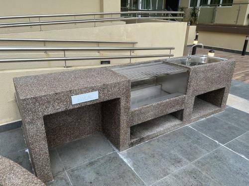 a stone bench sitting in front of a building at Singgahan @ Kuching Riverine Diamond in Kuching