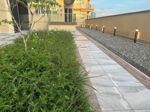 a sidewalk with plants next to a building at Singgahan @ Kuching Riverine Diamond in Kuching