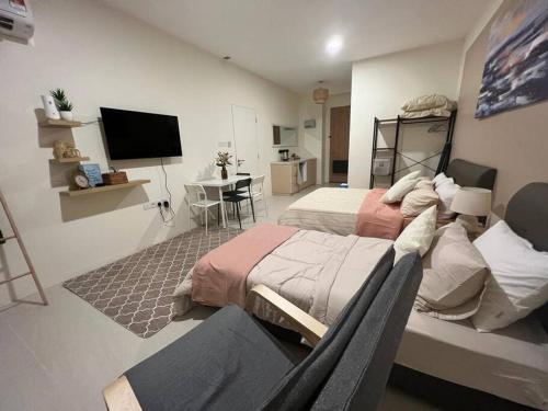 a bedroom with two beds and a flat screen tv at Singgahan @ Kuching Riverine Diamond in Kuching