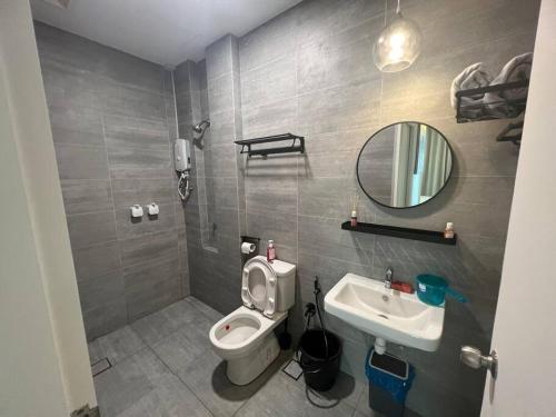 a bathroom with a toilet and a sink and a mirror at Singgahan @ Kuching Riverine Diamond in Kuching