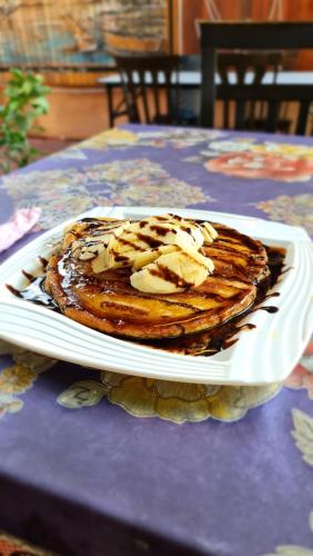 a stack of pancakes on a plate on a table at AA Backpackers Hostel in Pantai Cenang