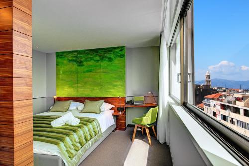 斯普利特的住宿－地平線豪華套房酒店，一间卧室设有一张床和一个大窗户