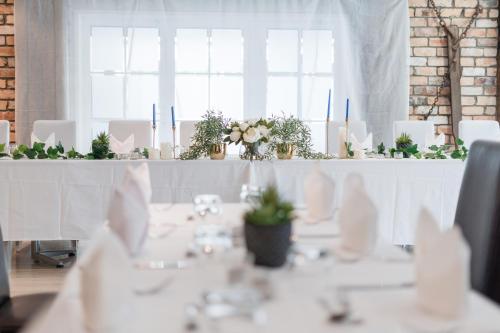 a table with white table cloths and plants on it at Northridge Golf Resort in Orewa