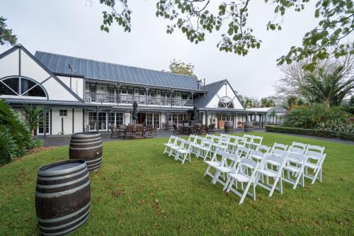 a row of white chairs in front of a building at Northridge Golf Resort in Orewa