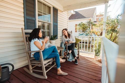 two women sitting on the porch of a house at East Stevens Home in Culpeper