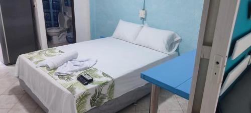 プエルト・トリウンフォにあるcabaña 81 santorini colombianoのベッドと青いテーブルが備わる小さな客室です。