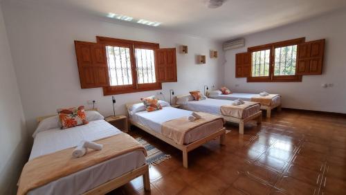 pokój z 3 łóżkami w pokoju z oknami w obiekcie Villa Lucía - Benalmádena Costa w mieście Benalmádena