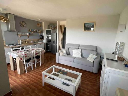 a living room with a couch and a table at Charmant 2 pièces avec vue sur mer à Porticcio en Corse du Sud in Porticcio
