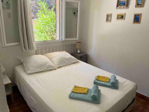 a bedroom with a bed with two towels on it at Charmant 2 pièces avec vue sur mer à Porticcio en Corse du Sud in Porticcio