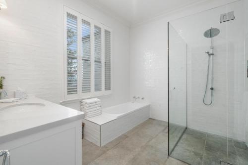a white bathroom with a shower and a sink at Mansfield Manor in Barwite