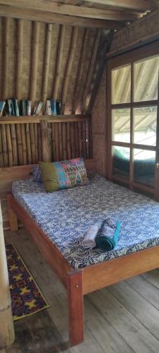 a large bed in a wooden room in a cabin at Bamboo hut Alpha Hotel in Maluk