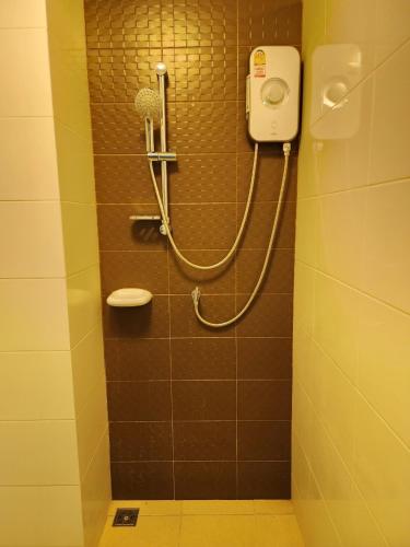 a shower in a bathroom with a hair dryer at The Trust Condo by the Sea in Hua Hin