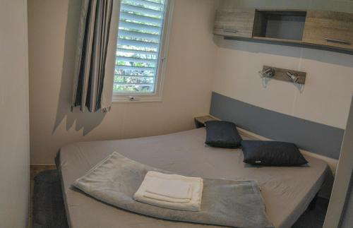 Mobile homes Pine Sea Banjole في بنجول: غرفة صغيرة بها سرير ونافذة