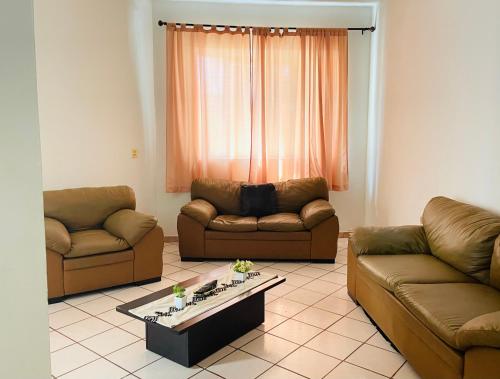 a living room with two couches and a coffee table at Casa Baraka, Casa Vacacional en Mazatlán cerca de Malecón, Centro Histórico y Playa in Mazatlán