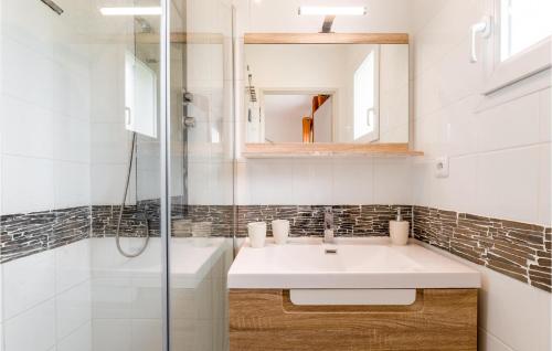 Baño blanco con lavabo y espejo en Nice Home In Lyons-la-fort With House A Panoramic View, en Lyons-la-Forêt