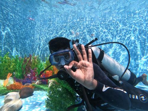 a man taking a picture of a diver in the water at Holiday Tourisms Group of Homestay Food Scuba Diving Boating Watersports-Tarkarli-Devbag Beach in Bhogwe