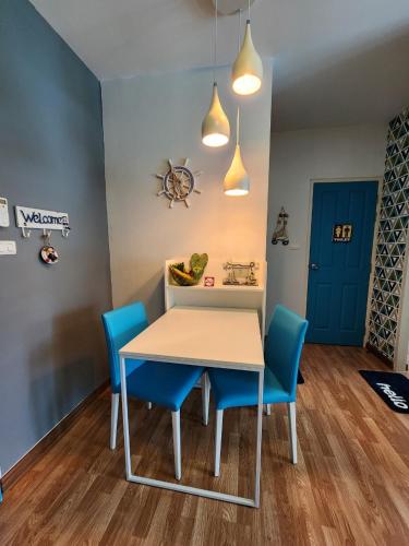 a dining room with a table and blue chairs at The Trust Condo by the Sea in Hua Hin