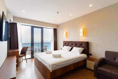 een hotelkamer met een bed en een balkon bij Orbi Beach 33 floor with great view in Batoemi