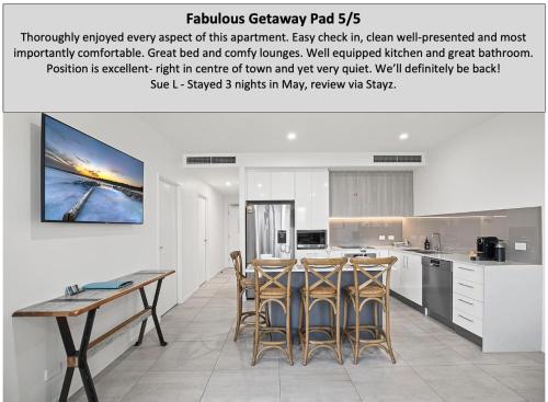 a kitchen with a table and chairs in a room at Rockpool 2 Sawtell Beach - Just steps to Restaurants and 2 min Stroll to Beach! in Sawtell