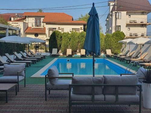 a swimming pool with lounge chairs and an umbrella at Vila EPIC in Costinesti