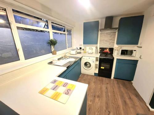 a kitchen with blue cabinets and a white counter top at JB Stays /Free Parking/Family/Contractors in South Norwood