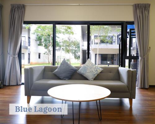 uma sala de estar com um sofá e uma mesa em Roxy Sematan Townhouse - Blue Lagoon em Sematan