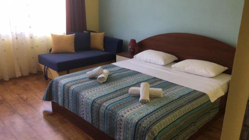 a bedroom with a bed with two towels on it at Свети Кирил Лозенец in Lozenets