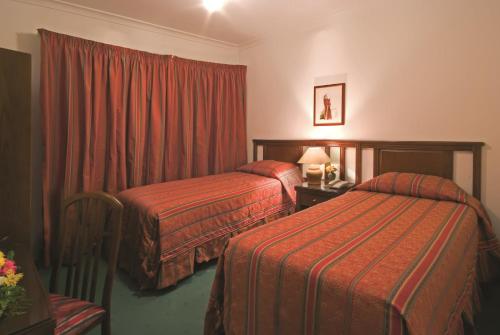 una camera d'albergo con due letti e una finestra di Delmon Suites ad Amman