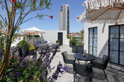 een patio met een tafel, stoelen en bloemen bij Allegro Neve Tzedek Boutique Suites - By HOMY in Tel Aviv