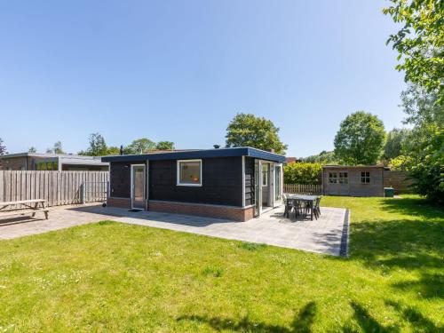 una pequeña casa negra diminuta con patio trasero en Gorgeous Holiday Home in Wolphaartsdijk with Garden, en Wolphaartsdijk