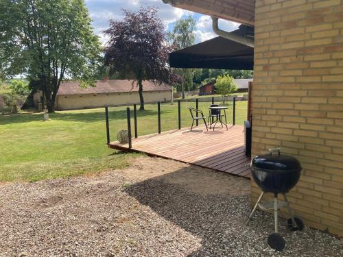 a wooden deck with a table and chairs on it at Hegedal Apartment in Hobro