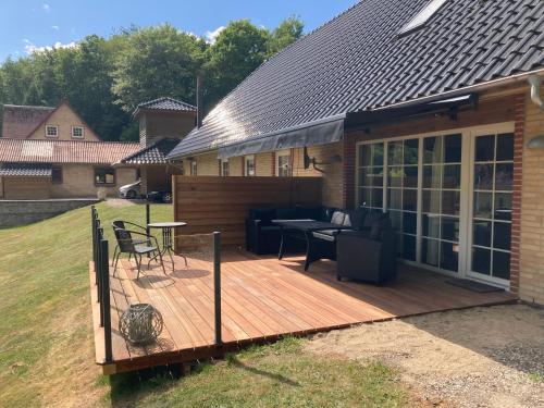 a wooden deck with a table and chairs on it at Hegedal Apartment in Hobro