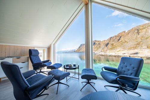 a room with a large window with chairs and a table at Lofoten Waterfront luxury lodge in Ballstad